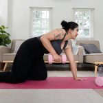 Determined Overweight Woman Exercising at Home with Dumbbells, Committed to Weight Loss and Fitness