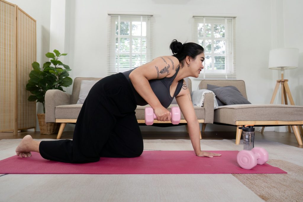 Determined Overweight Woman Exercising at Home with Dumbbells, Committed to Weight Loss and Fitness