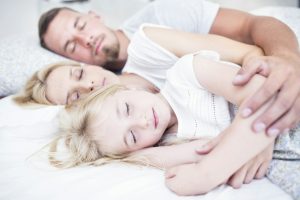 Family sleeping in bed